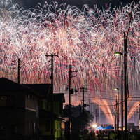 街から見る夜空を埋め尽くす大曲の打ち上げ花火の写真