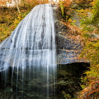 紅葉した木々と白糸の滝、岩手県和賀郡西和賀町の秋の風景の写真