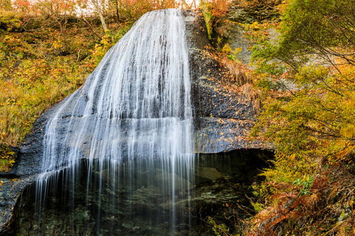 紅葉した木々と白糸の滝、岩手県和賀郡西和賀町の秋の風景