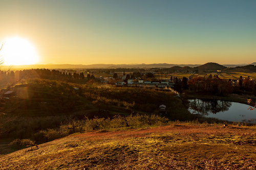 丘陵地帯に広がる町並みを染める夕焼けと夕日