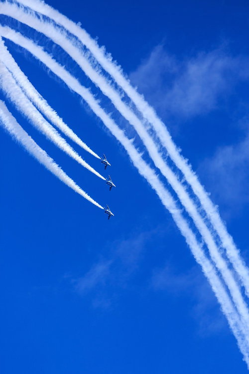 青空で宙返りを決めるブルーインパルスの編隊飛行