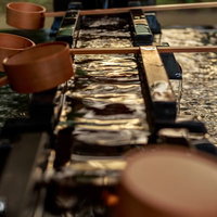 神社の手水舎に置かれた竹の柄杓と清水が湛えられた手水鉢の写真