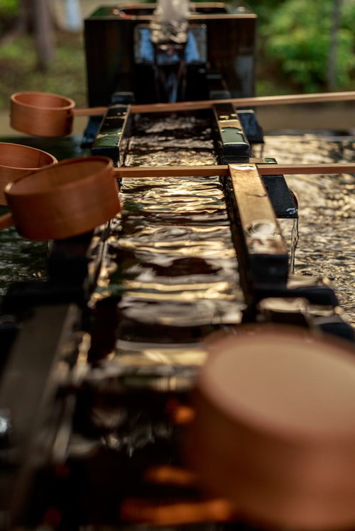 神社の手水舎に置かれた竹の柄杓と清水が湛えられた手水鉢