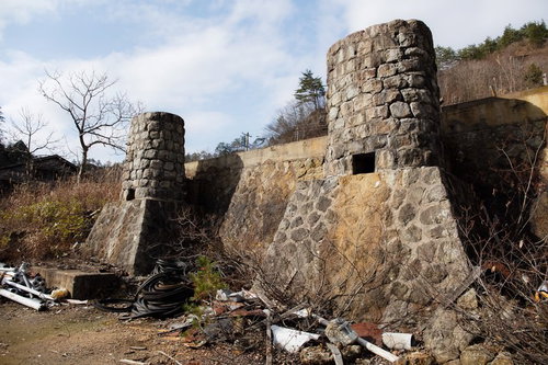 瓦礫が積もる土畑鉱山跡の石造建造物と風化した遺跡