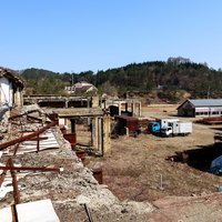 瓦礫と破棄されたトラックが残る廃墟の産業遺産跡の写真
