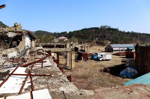 瓦礫と破棄されたトラックが残る廃墟の産業遺産跡