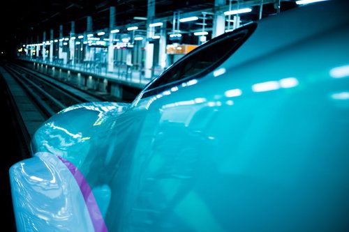 駅のホームに停車する新幹線はやぶさと乗客