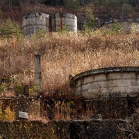 廃鉱の中に残された土畑鉱山の貯蔵タンクと産業遺産の写真