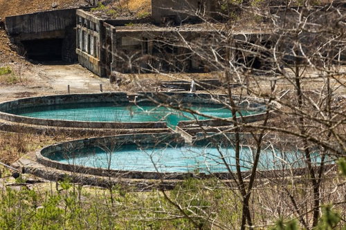 尾去沢鉱山の廃墟に残る青緑色の水槽と鉱山施設跡