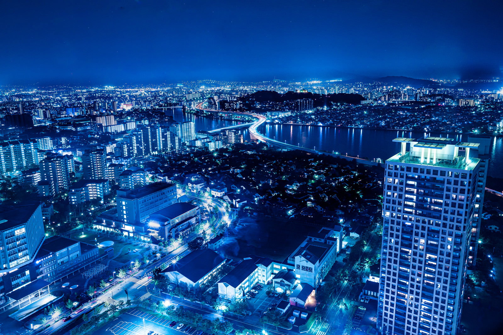 青くライトアップされた博多の夜景と高層ビル群
