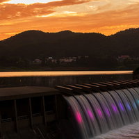 夕暮れの錦秋湖大滝、オレンジ色の空に虹色に輝くの写真