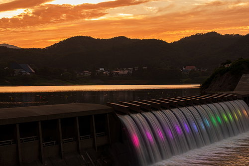 夕暮れの錦秋湖大滝、オレンジ色の空に虹色に輝く