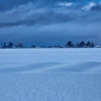 凍結した湖面を覆う田舎の積雪と冬の静寂、北国の寒冷地の風景の写真