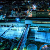 雪が積もる盛岡駅ホームの夜景、青白い照明に照らされた線路の写真