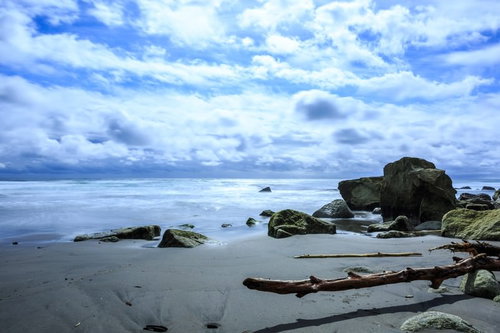 イタンキ浜の砂浜に点在する流木と岩のある海岸風景