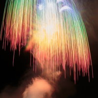 夜空に咲くレインボー色のしだれ柳型打ち上げ花火の写真