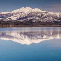 田沢湖面に映る雪の秋田駒ヶ岳の水鏡風景の写真