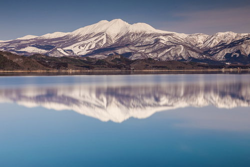 田沢湖面に映る雪の秋田駒ヶ岳の水鏡風景