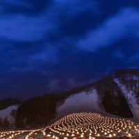 雪山を背景に灯籠が並ぶ夜のかまくら。弘前津軽の冬祭りの写真