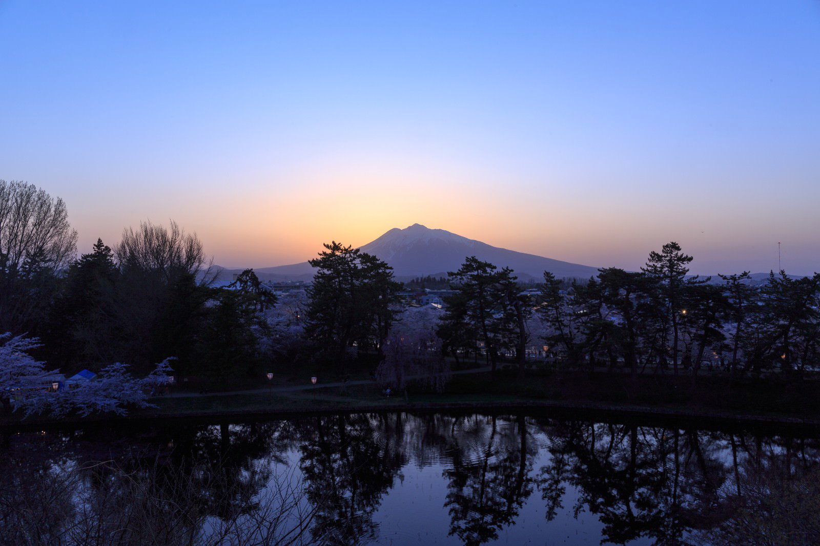 弘前公園から望む夕暮れの岩木山と池の反射