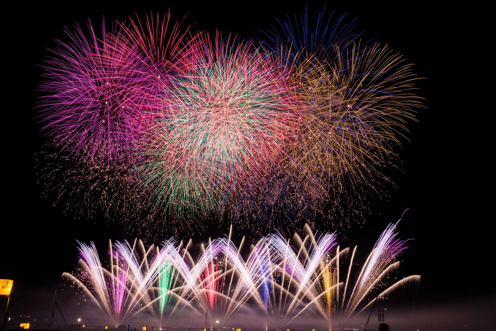 夜空に広がる打ち上げ花火と噴出花火