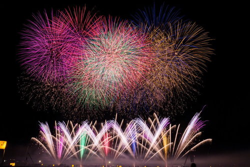 ド派手な打ち上げ花火と噴出花火の共演！夏祭りの夜空を彩るカラフルな花火