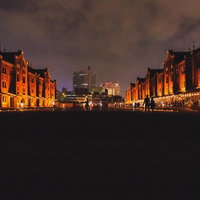 夜間ライトアップされた横浜赤レンガ倉庫の夜景と来園者の写真