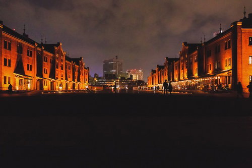 夜間ライトアップされた横浜赤レンガ倉庫の夜景と来園者