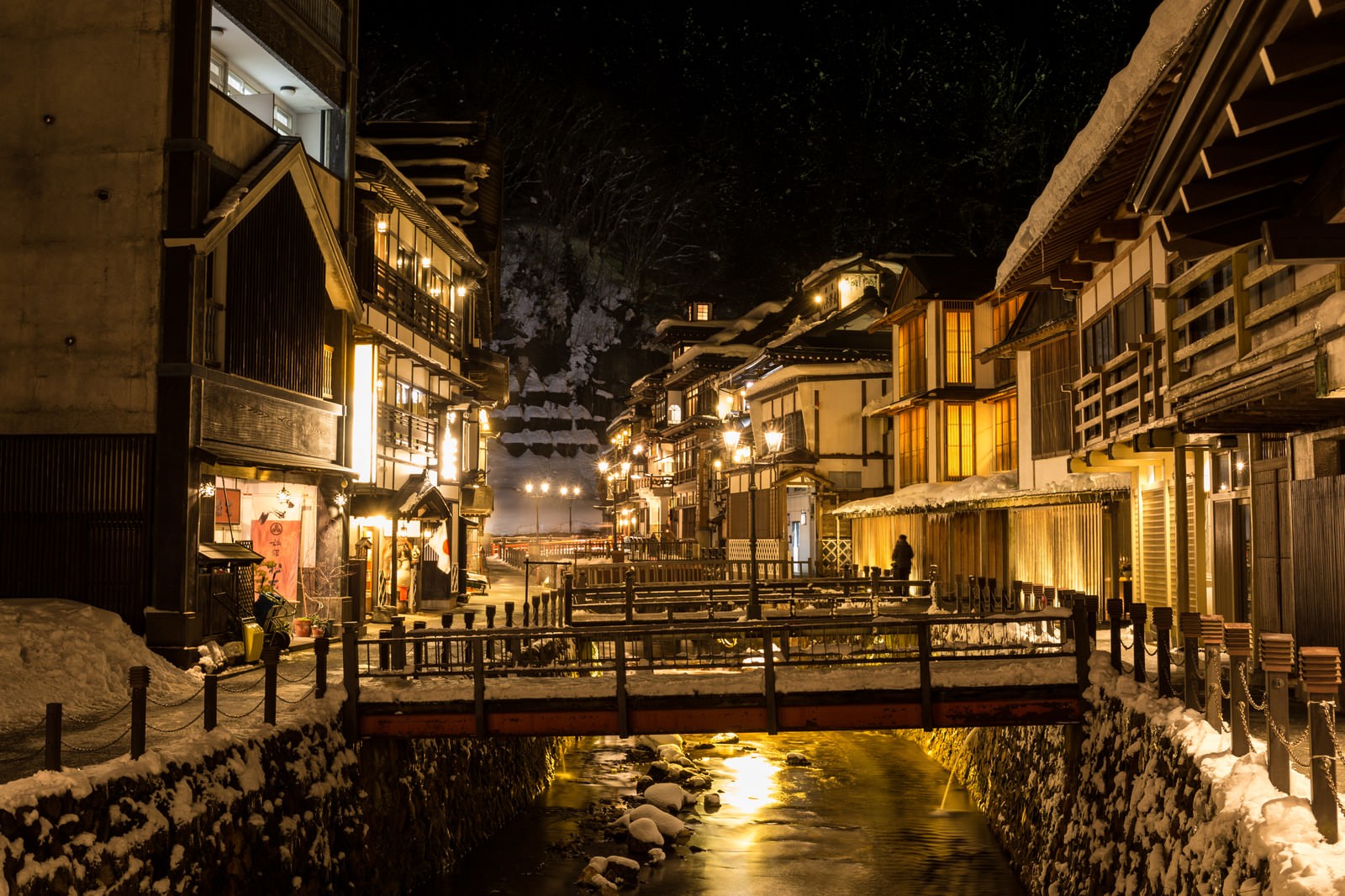 夜間にガス灯で照らされた銀山温泉の旅館街と雪景色