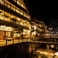夜間にライトアップされた積雪の銀山温泉街の写真