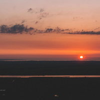 沈みゆく夕陽と雲の風景 地平線に沈む太陽と空の写真