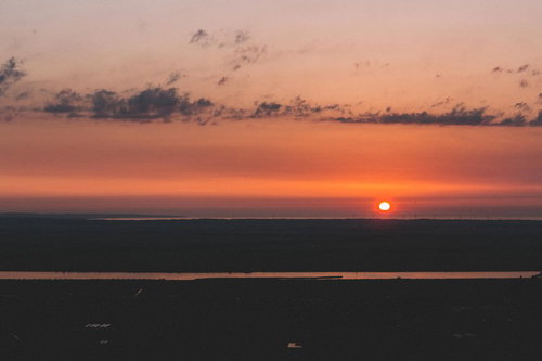 沈みゆく夕陽と雲の風景 地平線に沈む太陽と空