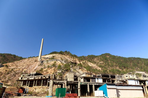 尾去沢鉱山跡の廃墟と青空、露出した山肌とコンクリート建造物