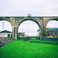 大間鉄道廃線跡に残る石造りのめがね橋と周辺風景の写真