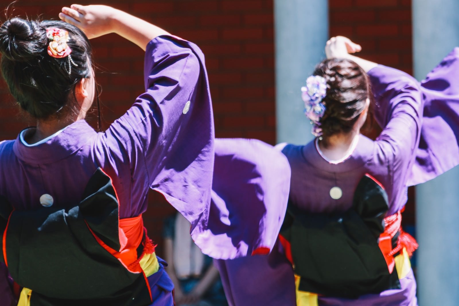 紫の衣装に赤い帯を締めた女性たちが、髪飾りをつけて踊っている角館のおやま囃子の様子