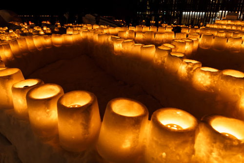 夜間に雪灯篭がずらりと並ぶ冬の風景