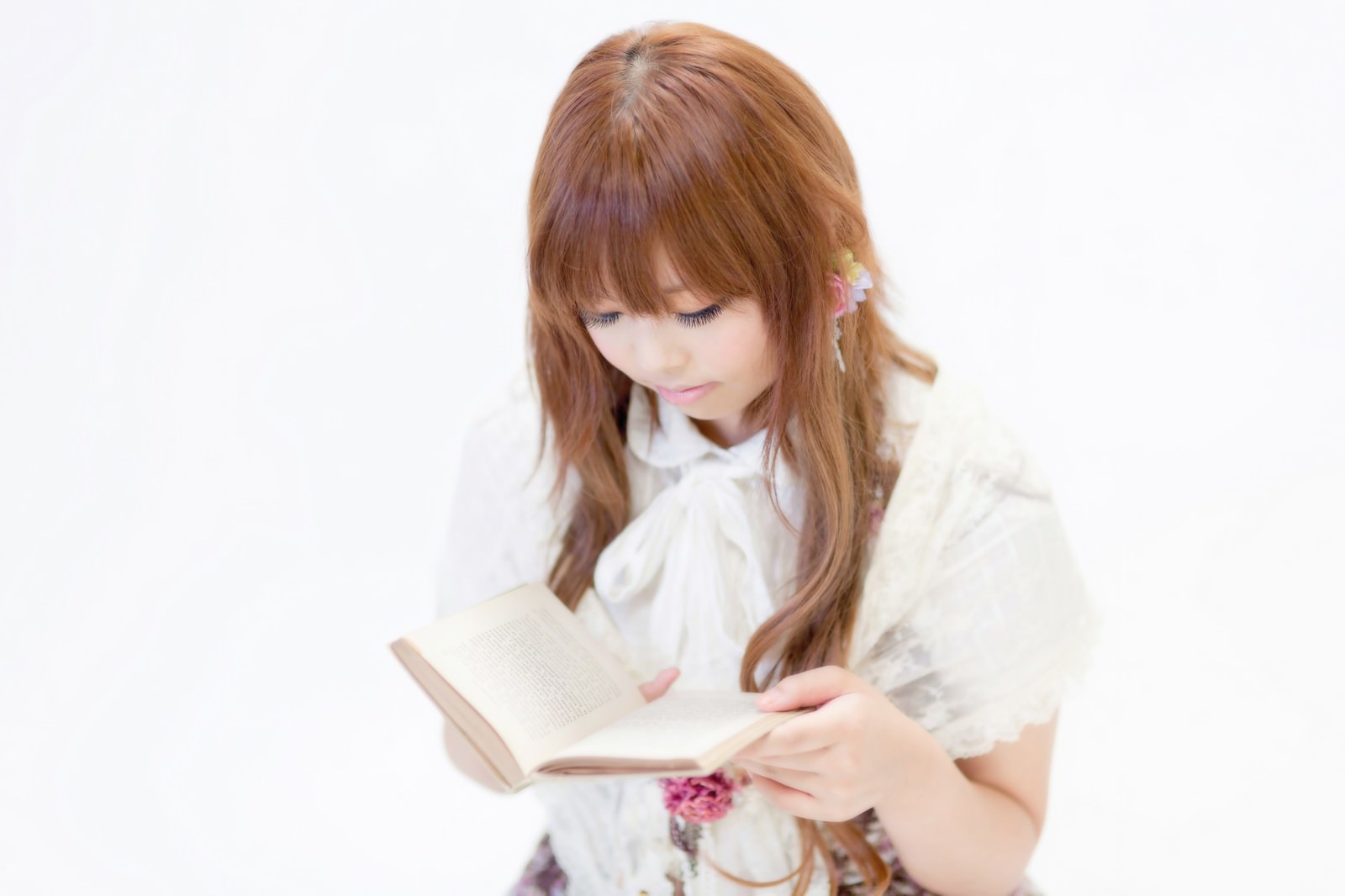 白いシャツ姿で本を読む茶髪の女性、髪飾りをつけた横顔［モデル：あみ］