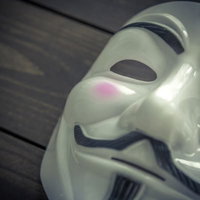 匿名性の高い仮面をかぶったハッカーのポートレートの写真