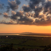 八郎潟に沈む夕日と雲、水面に映る金色の光景の写真