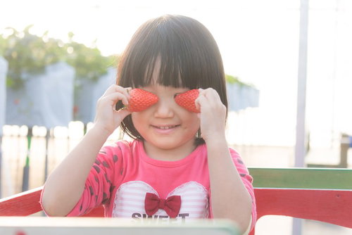 いちご少女が目元を隠して遊ぶ春の苺狩り体験