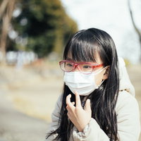 花粉防止用めがねとマスクを装着する女の子の写真