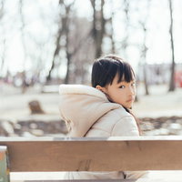 ベンチに座って振り返る、ご機嫌ななめの愛娘の写真