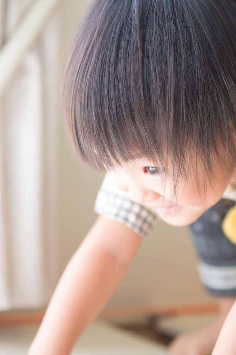 手で口元を覆う前髪が目にかかる子供の室内ポートレート［モデル：あんじゅ］