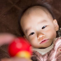 仰向けで手を伸ばす赤ちゃんの写真