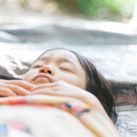 疲れて寝ちゃった女の子の昼寝姿、穏やかな寝顔の写真