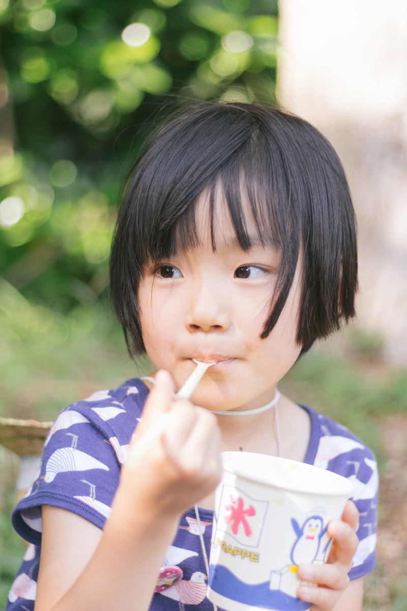 スプーンでかき氷を食べているボーダーシャツの女の子