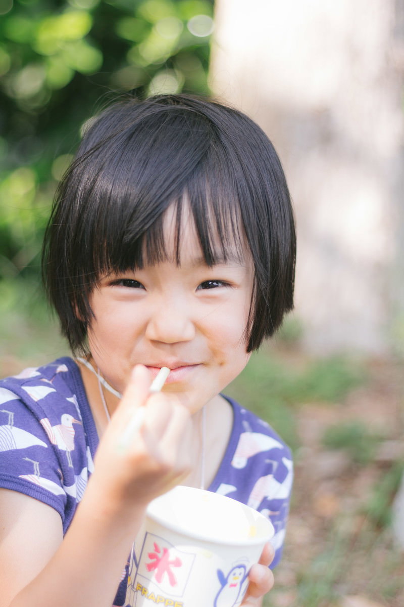 かき氷を食べて満足そうな笑顔を浮かべる紫色のトップスを着たボブヘアの女の子［モデル：あんじゅ］