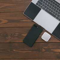 スマートフォンと小型のワイヤレススピーカーとMacBookの写真