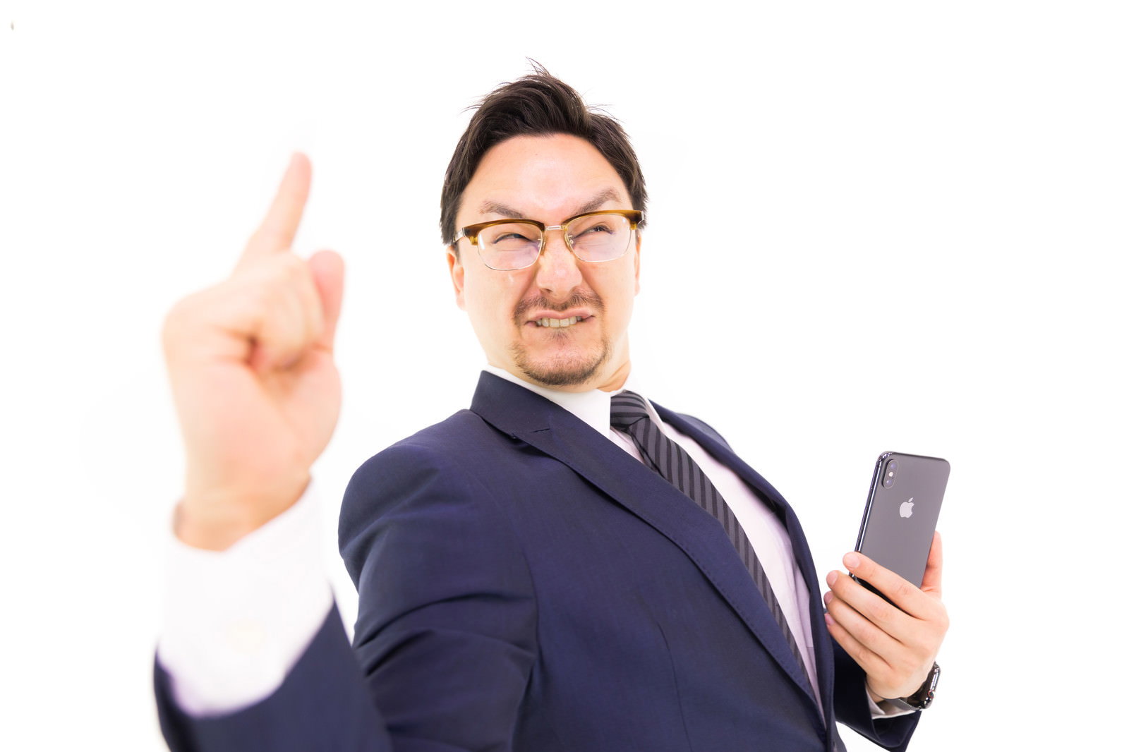 iPhoneを持ちドヤ顔でポーズするスーツの男性［モデル：Max_Ezaki］