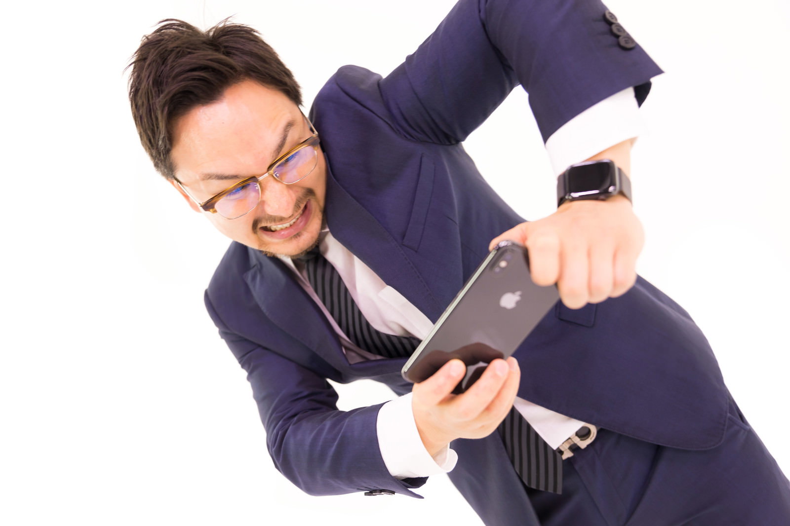 スマホに拳を振り下ろすスーツ男性［モデル：Max_Ezaki］